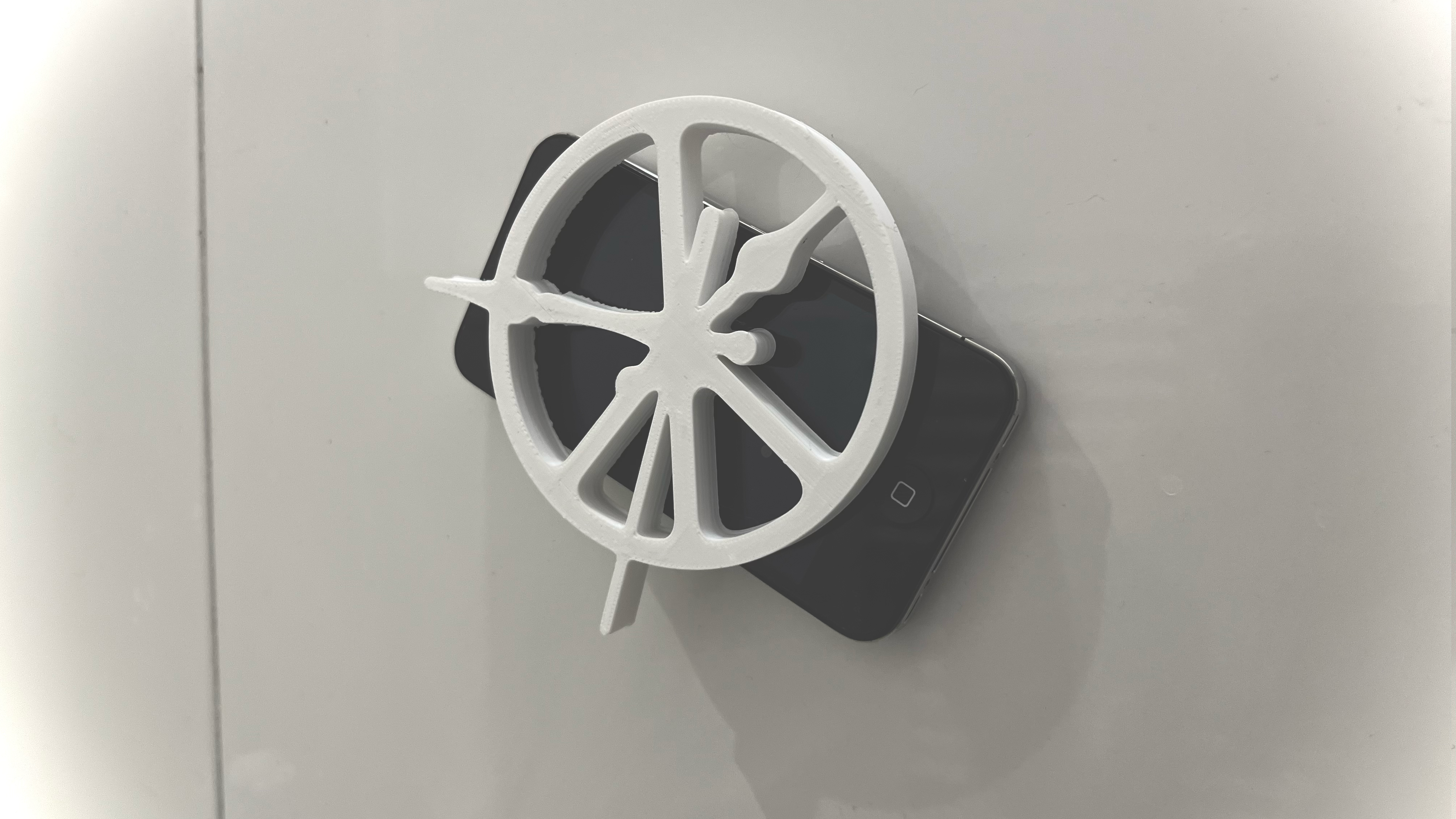 White peace and clock symbol resting on a phone, second view